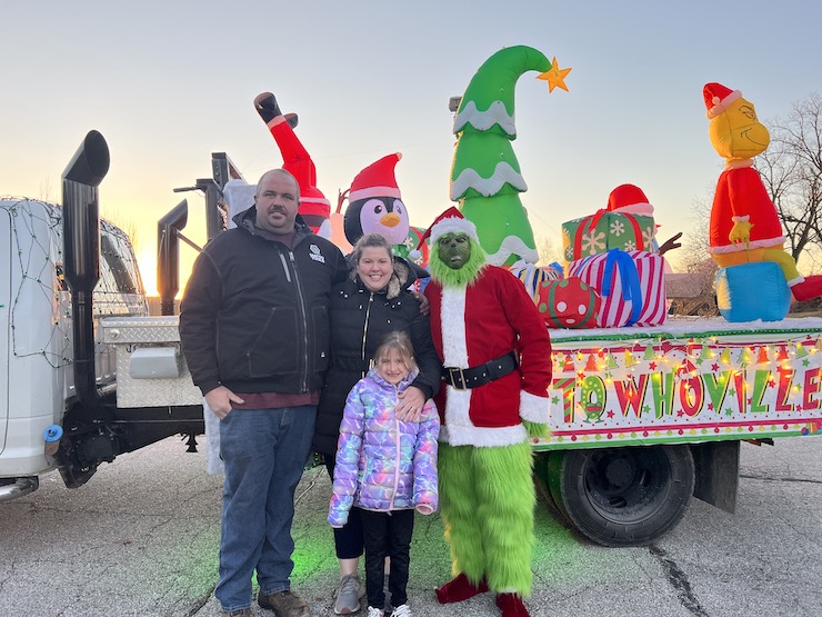 Vale family with the Grinch pose for a photo in front of the truck